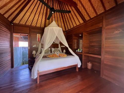 蓝梦岛Gatri Hut的一间卧室配有一张带蚊帐的床