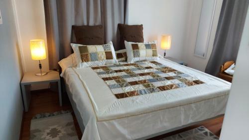 康隆尼角Tropical Palms apartment Mauritius的一间卧室配有一张大床和两盏灯