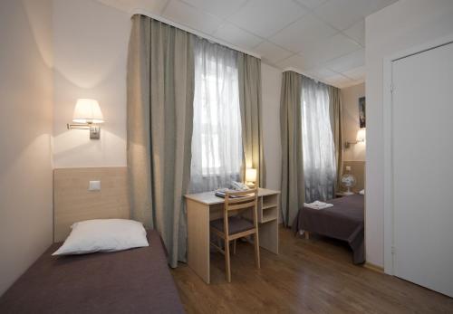 里加Hotel BEST with FREE PARKING的一间卧室配有一张床、一张书桌和一个窗户。