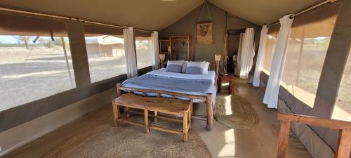 塞伦盖蒂Zawadi Camp的一间设有床铺的卧室,位于带窗户的房间内
