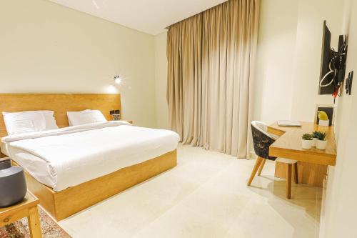 开罗NewCity Hotel & Suites的酒店客房配有一张床、一张书桌和一张书桌。