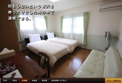 Minami-komatsuアルヴィラ近江舞子的一间设有两张床和一张沙发的房间