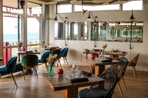 圣马洛阿尔恩尼兹酒店的餐厅设有木桌、椅子和窗户。