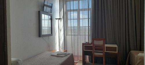 旧蒙特莫尔Hotel Abade João的卧室配有床、椅子和窗户。