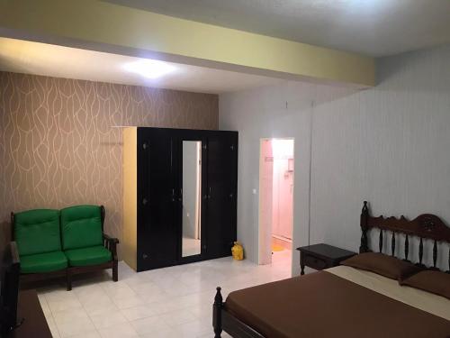 埃斯帕戈斯CA FILO的一间卧室配有一张床和两张绿色椅子