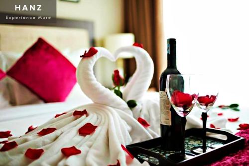 河内HANZ Regal Hotel Hanoi的两个天鹅坐在桌子上,边喝一瓶葡萄酒