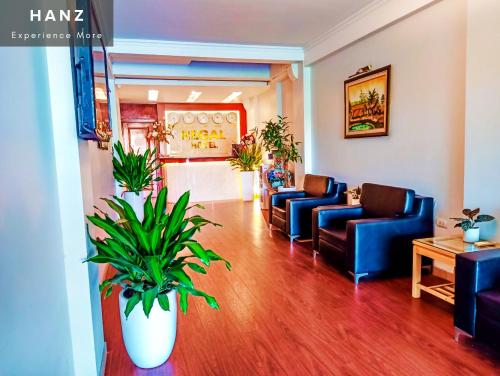 河内HANZ Regal Hotel Hanoi的一间设有蓝色沙发和盆栽植物的等候室