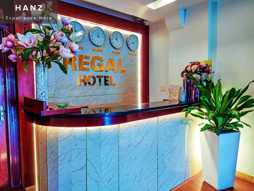 河内HANZ Regal Hotel Hanoi的酒店大堂,带有热带酒店标志和鲜花