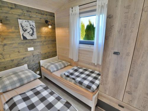 尤斯托尼莫斯基Year-round cottage for 2 people, Ustronie Morskie的客房设有两张床和窗户。