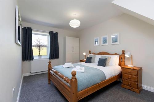 CoundonAuckland View - a comfy & spacious 4bed with views的一间卧室设有一张大床和一个窗户。