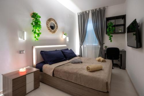 米兰Duomo a 15 minuti di Metro-Suite con Netflix ad Affori M3的一间卧室配有一张带蓝色枕头的床和一扇窗户。