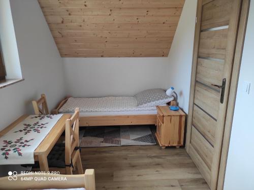 Ochotnica DolnaDomki Pod Brzyzkiem的小房间设有一张床和一张桌子