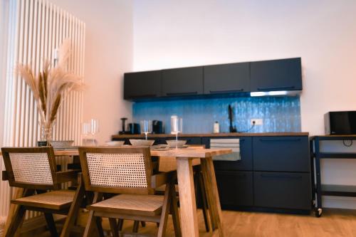 柏林The Weinert Suites的厨房配有木桌、椅子和柜台