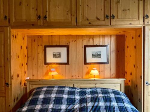 圣莫里茨Sankt Moritz Chesa Ruinatsch 50的卧室配有一张床,墙上挂有两张照片