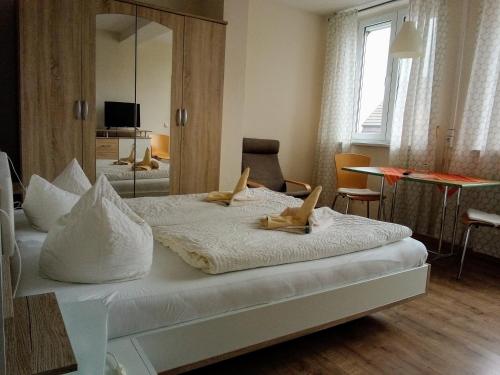 于克里茨Hotel Ratscafe Ückeritz的卧室配有一张带镜子的白色大床