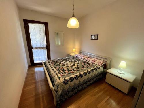 GiustinoPinzolo Centro - Baita Spaziosa con Vista sui Monti的一间卧室设有床、窗户和一盏灯。