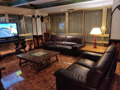 阿兰达德杜洛茱莉亚酒店的客厅配有皮革家具和平面电视