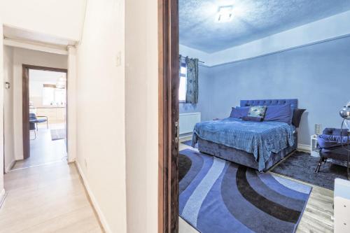 伦敦Stunning, large 1 bed riverside flat的一间卧室设有一张床和蓝色的墙壁