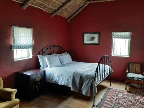 里弗斯代尔Zeekoegat Historical Homestead的卧室配有红色墙壁内的一张床
