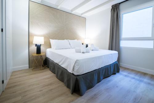 马拉加Apartamentos Málaga Premium - Calle San Telmo的窗户客房内的一张大白色床