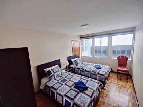 拉巴斯Cómodo, amplio y céntrico apartamento en Sopocachi的一间卧室配有两张床和红色椅子