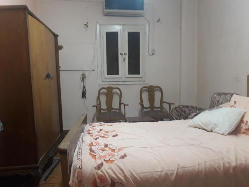 Quḩāfahمنطقة الاستاد بطنطا的一间卧室配有一张带两把椅子的床和一扇窗户