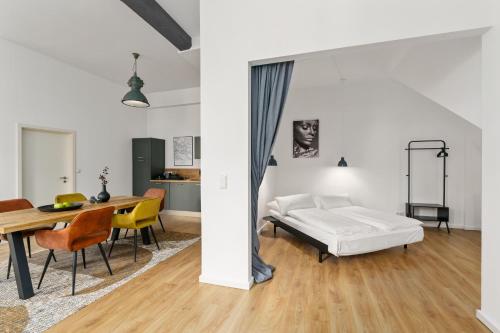 不莱梅Loft-Appartements mit Terrasse的卧室配有一张床和一张桌子及椅子