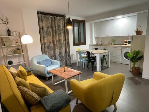 哈恩Coello 31的客厅以及带黄色沙发和椅子的厨房。