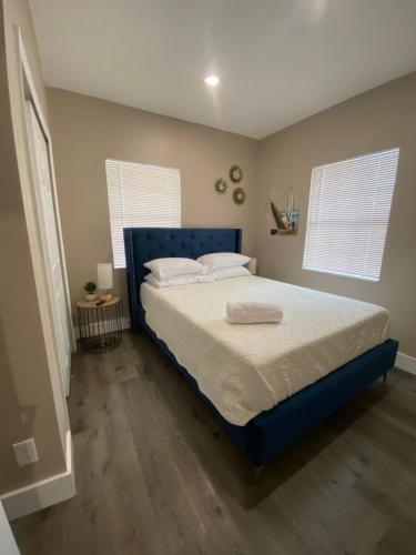 桑福德Bella Breeze的一间卧室配有一张带蓝色床头板的床和两个窗户