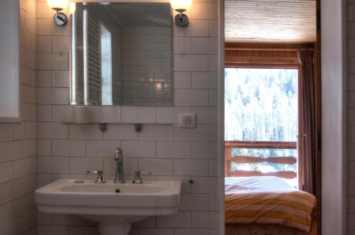 夏蒙尼-勃朗峰La Ribambelle的一间带水槽和镜子的浴室以及一张床