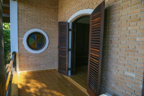 卡拉瓜塔图巴Casa da Cocanha COND com PISCINA-SINUCA-CHURRASQ-DECK com vista para o mar的砖墙,有门和窗户