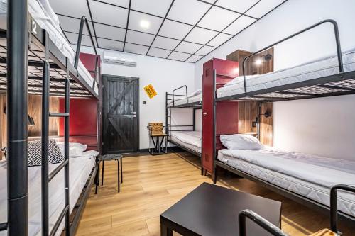 华沙VARSAVIA Hostel的客房设有三张双层床和一张桌子。
