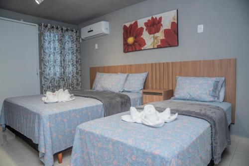 佩尼亚Suítes 590的两张位于酒店客房的床,配有毛巾