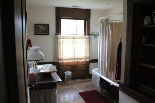 埃尔金斯Upstairs Historic 1 Bedroom 1 Bath Suite with Mini-Kitchen, Porch & River Views的客房设有窗户和带台灯的桌子