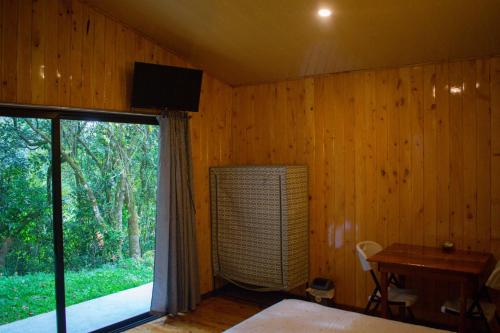 蒙泰韦尔德哥斯达黎加Cabañas Lys的一间卧室配有一张床、一个窗口和一张书桌