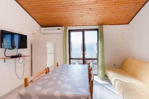 洛帕Apartments Ljubica J的客房设有桌子、沙发和电视。