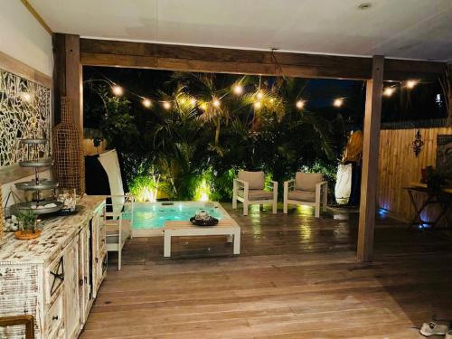 悉尼Bondi Boho House Jacuzzi PoolSpa HolidayRento的庭院设有游泳池、桌子和椅子。