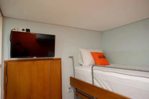 梭罗KoolKost @ Inep Kayu Jebres的一间卧室配有一张床和一台平面电视