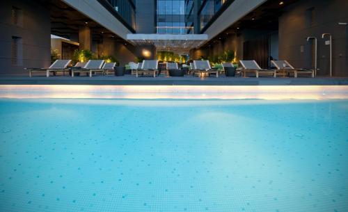 新加坡新加坡 Studio M 酒店的一座配有桌椅的酒店游泳池