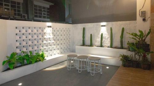 巴图Villa Shiny with Karaoke & Chill Spot的一间设有两张凳子和盆栽的房间