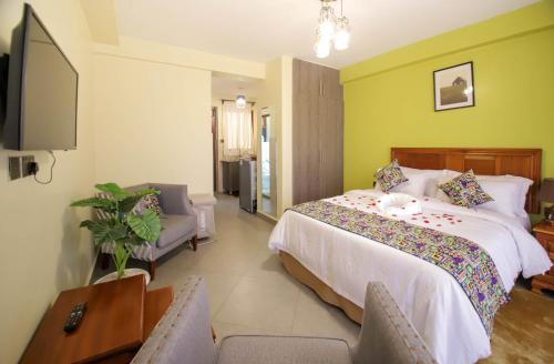 内罗毕Lantern Serviced Apartments的一间卧室配有一张床、一台电视和一张沙发