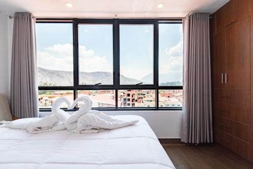 乌鲁班巴Town Center Apartments的两个天鹅坐在窗前的床上