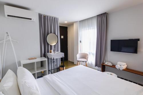 曼谷Chocolate box mint - SHA Plus的酒店客房配有白色的床和镜子