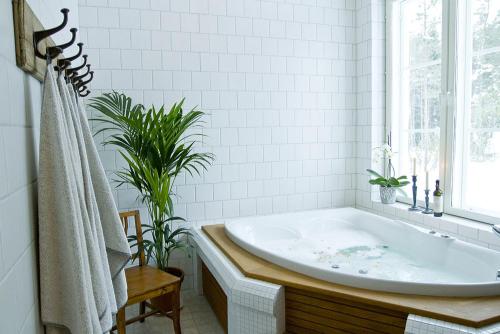 Inkoo韦斯特比嘉德酒店的白色的浴室设有浴缸和窗户。