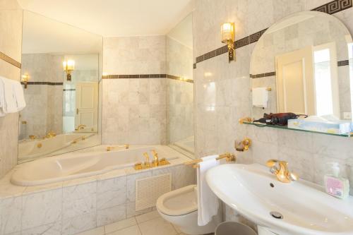 因特拉肯大陆中央酒店的带浴缸、卫生间和盥洗盆的浴室