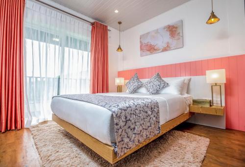 努沃勒埃利耶The Breeze Luxury Apartment的一间卧室配有一张带红色窗帘的大床