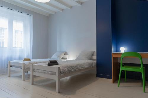 OrgeletL'Orgelétaine : Grande Maison au milieu des Lacs du Jura的一间卧室配有一张床、一张桌子和一把绿色椅子