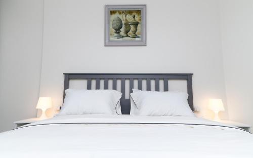 `Ezbet Shalabi el-RûdiPorto Said luxury hotel rentals的一张带两个白色枕头和两盏灯的白色床