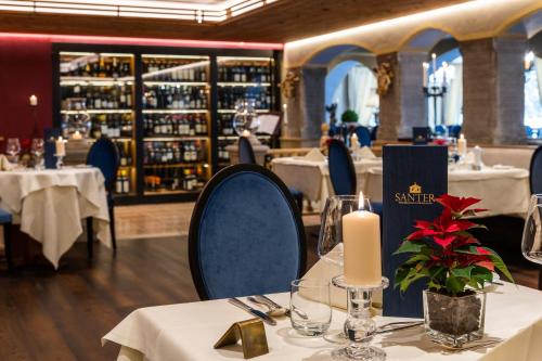多比亚科桑特罗曼蒂克酒店的餐厅配有白色的桌椅和蜡烛