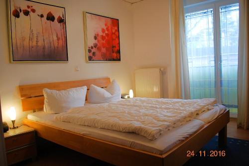 黑灵斯多夫Strandoase-Whg-16的卧室配有一张带白色床单和枕头的大床。